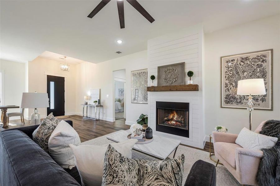 Cozy focal point fireplace with clean-lined shiplap surround and weathered wood mantel exudes warmth and character. Thoughtfully design for a seamless flow from living spaces to private wing ensures both entertaining ease and everyday comfort.