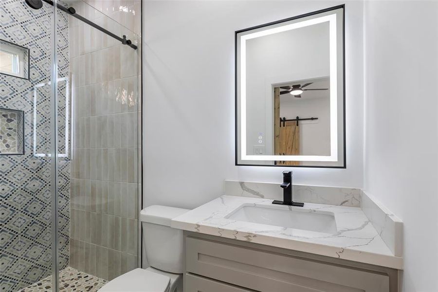 Look at this Gorgeous tile work in the walk-in shower! This room also features a Quartz counter with a solid wood cabinet and a frameless LED mirror.