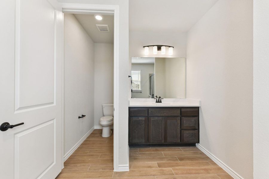 Full bath with vanity, wood tiled floors, and a shower stall
