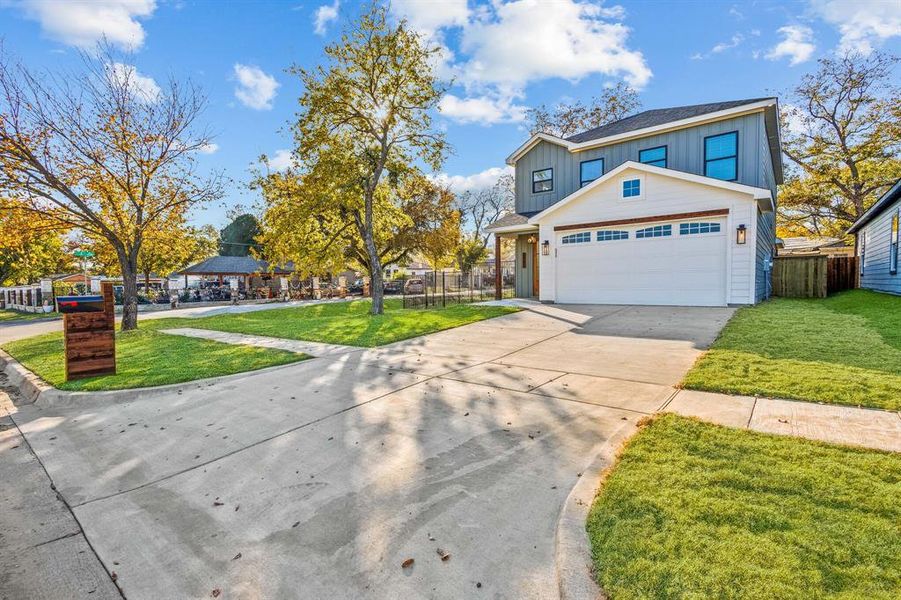 View of front of property featuring a front yard and a garage