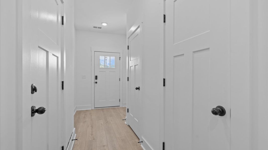 Memorable arrival experience with hardwood floors and elegant trim in the foyer