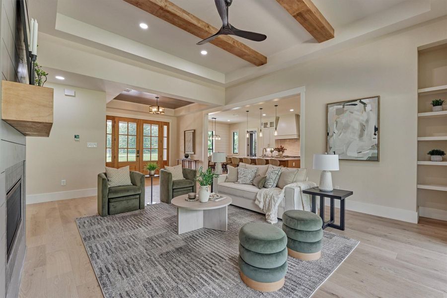 Open-concept living at its best: this great room flows seamlessly into the kitchen and dining areas, with the front entry's double mahogany doors visible just beyond. Built-in shelving, custom beams, and a gas fireplace round out the comfort. Open-concept living at its best: this great room flows seamlessly into the kitchen and dining areas, with the front entry's double mahogany doors visible just beyond. Built-in shelving, custom beams, and a gas fireplace round out the comfort.