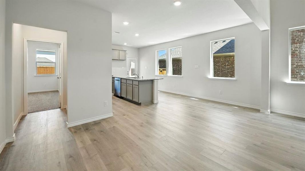 Kitchen with a kitchen island with sink, gray cabinets, recessed lighting, light wood finished floors, and plenty of natural light