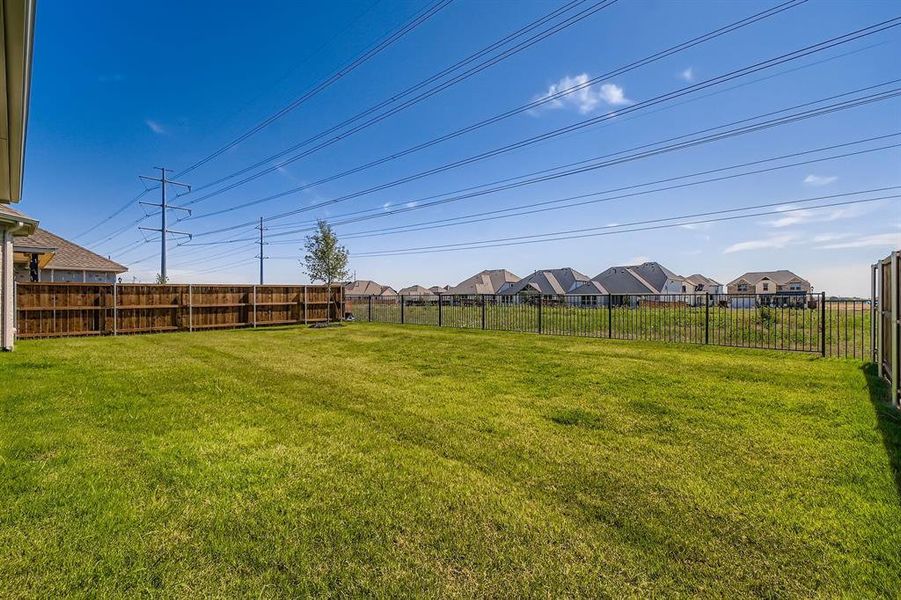 Fenced backyard featuring a residential view