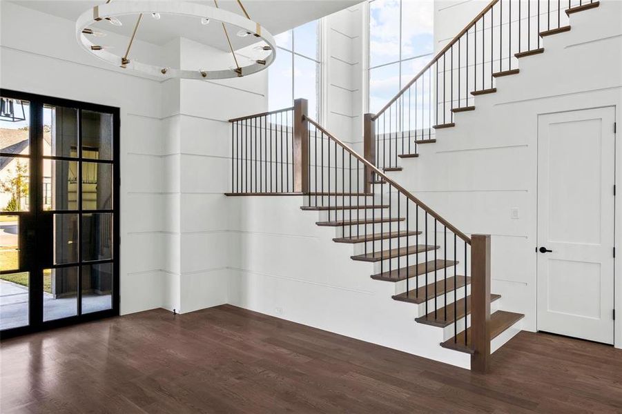 Stairs featuring plenty of natural light and wood finished floors Stairs featuring plenty of natural light and wood finished floors