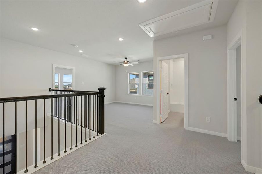 Hall featuring light carpet, recessed lighting, and an upstairs landing