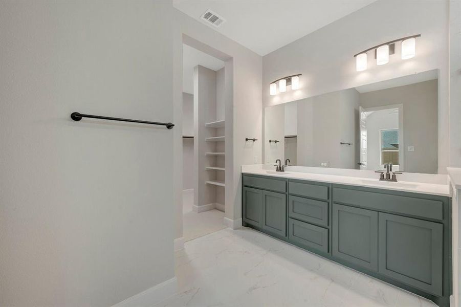 Bathroom featuring a dual vanity with a white countertop and blue-grey cabinetry
