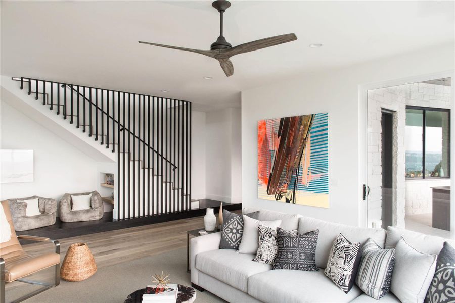 Living area featuring wood finished floors, stairway, a ceiling fan, and recessed lighting