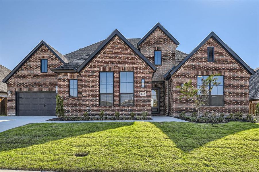 View of front of house with a front lawn and a garage