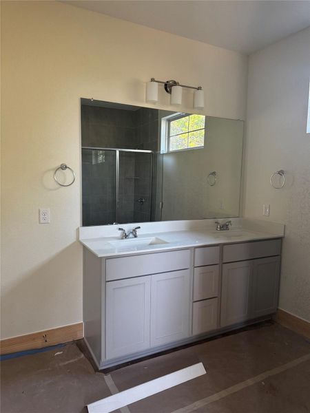 Full bath featuring double vanity and a stall shower Full bath featuring double vanity and a stall shower