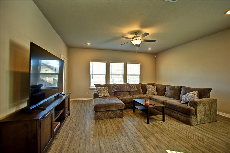 Living room with ceiling fan, wood-type flooring, and recessed lighting Living room with ceiling fan, wood-type flooring, and recessed lighting