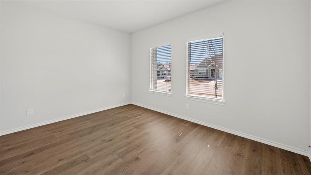 Unfurnished room featuring dark wood-type flooring and baseboards