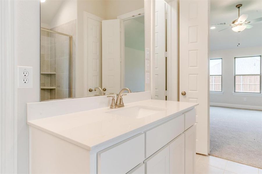 Bathroom featuring vanity, tile patterned flooring, and ceiling fan