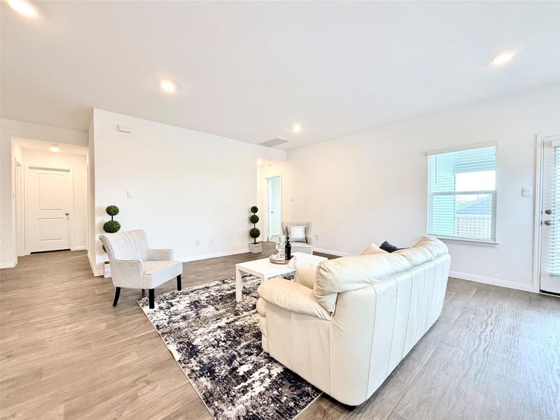 Living area with light wood-style floors and recessed lighting Living area with light wood-style floors and recessed lighting