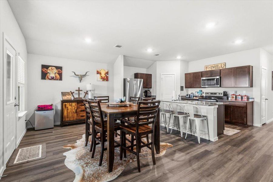 Dining space with dark wood finished floors and recessed lighting