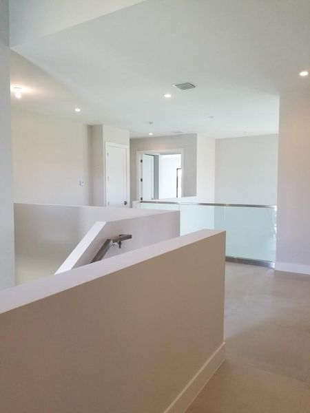 Photo from previously built Deerwood Model Home.  Upstairs hallway with optional glass railing