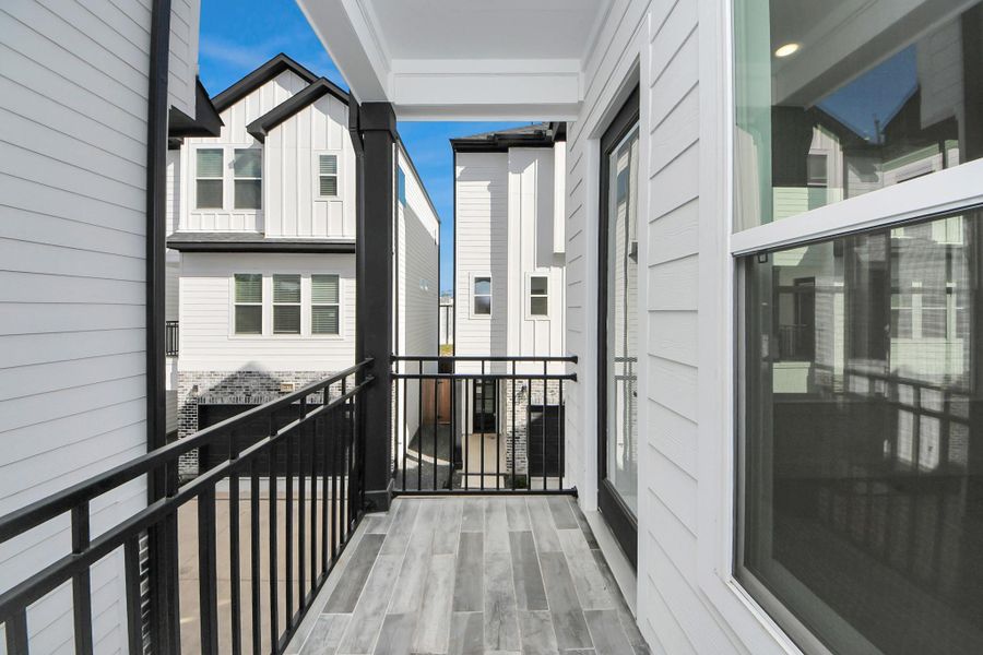 This photo showcases a modern balcony with sleek metal railings and a wood-look tile floor, offering a view of neighboring contemporary homes. The area is bright and airy, ideal for relaxing or enjoying a morning coffee. This photo showcases a modern balcony with sleek metal railings and a wood-look tile floor, offering a view of neighboring contemporary homes. The area is bright and airy, ideal for relaxing or enjoying a morning coffee.