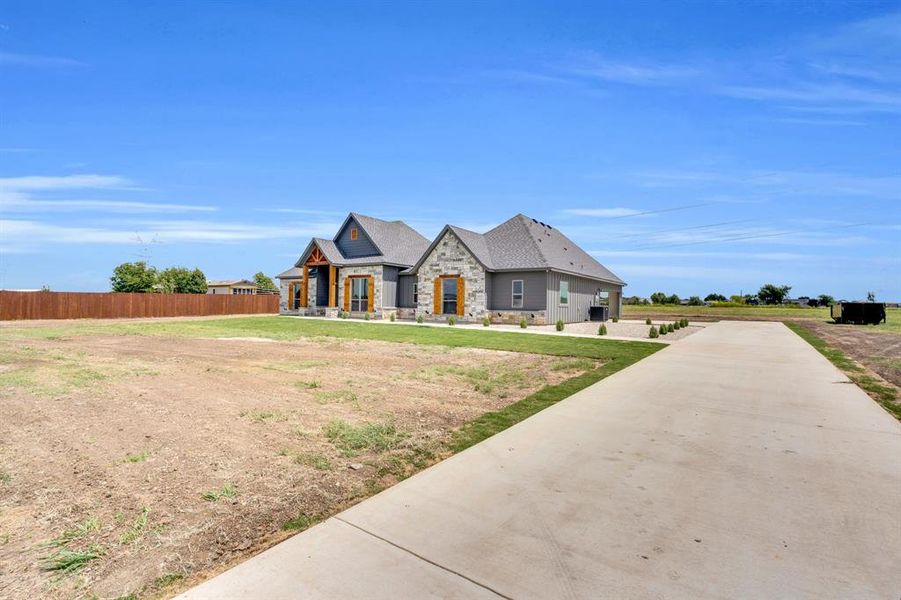 French country style house with stone siding and concrete driveway