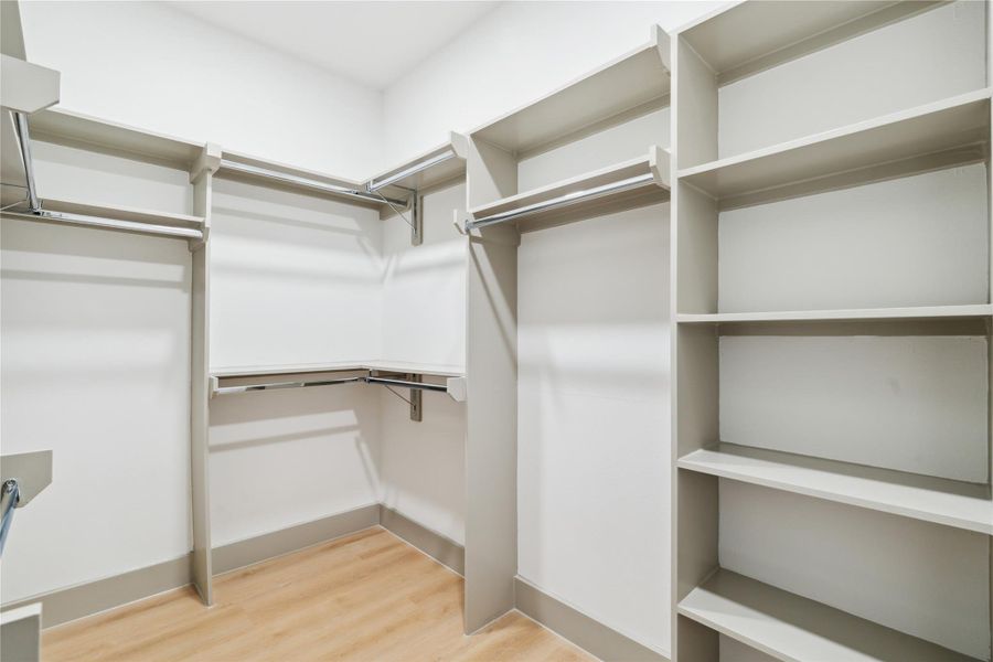 Custom shelving, double rods, and open corners create a space that’s as functional as it is serene.