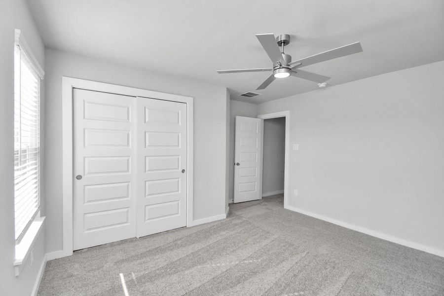 Generously sized secondary bedrooms featuring spacious closets, soft and inviting carpeting underfoot, large windows allowing plenty of natural light, and the added touch of privacy blinds for your personal retreat. Sample photo of completed home with similar floor plan. Actual colors and selections may vary. Generously sized secondary bedrooms featuring spacious closets, soft and inviting carpeting underfoot, large windows allowing plenty of natural light, and the added touch of privacy blinds for your personal retreat. Sample photo of completed home with similar floor plan. Actual colors and selections may vary.