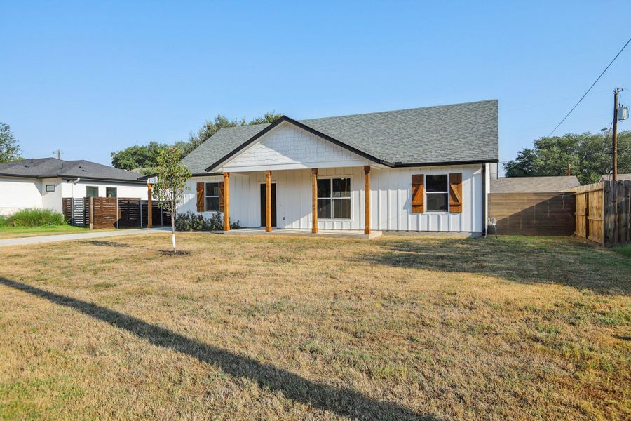 Modern farmhouse with covered porch, roof with shingles, and board and batten siding
