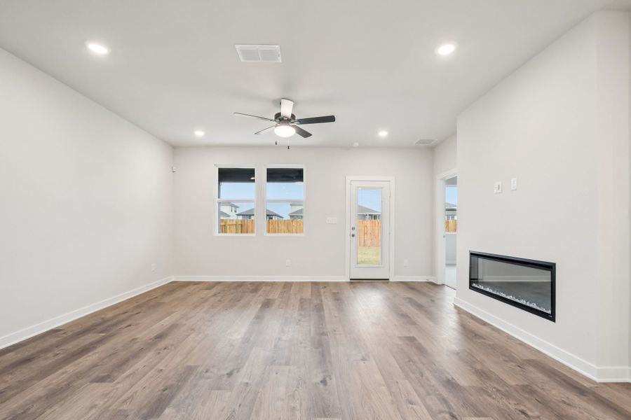 A room with a wood floor and a ceiling fan.