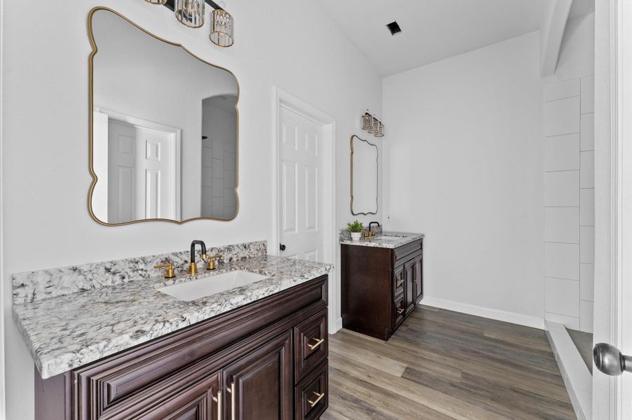 Luxurious en-suite with double vanity, framed mirrors, elegant fixtures, and a spa-like feel. Luxurious en-suite with double vanity, framed mirrors, elegant fixtures, and a spa-like feel.