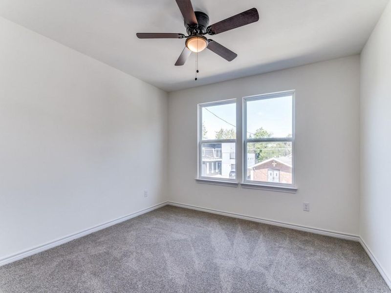 Carpeted spare room featuring ceiling fan