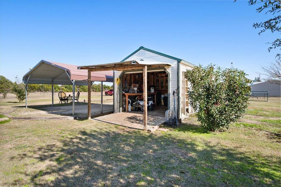 Detached outbuilding with a corrugated metal roof and an open-front workshop area