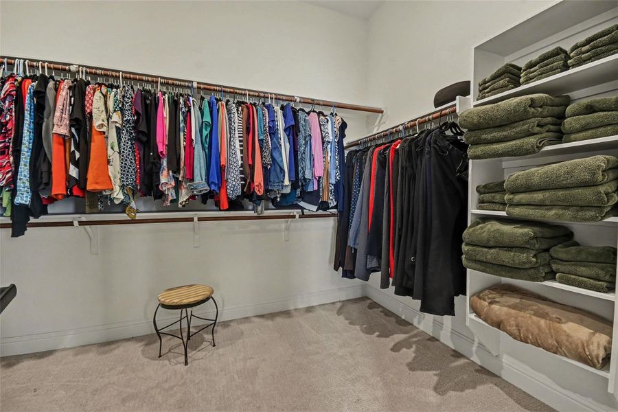 Spacious walk-in closet with ample hanging space and built-in shelves, perfect for organizing clothing and linens. Spacious walk-in closet with ample hanging space and built-in shelves, perfect for organizing clothing and linens.