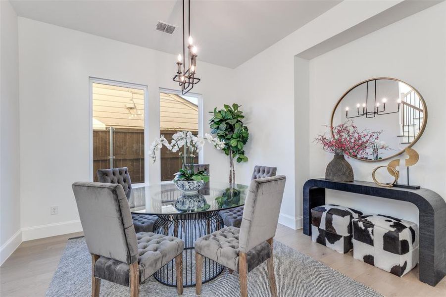 Breakfast/Dining area featuring a chandelier and light wood-style flooring Breakfast/Dining area featuring a chandelier and light wood-style flooring