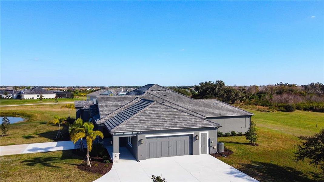 Front exterior of a new home in Hampton Lakes, Sarasota, FL, highlighting curb appeal (Image 26). Front exterior of a new home in Hampton Lakes, Sarasota, FL, highlighting curb appeal (Image 26).