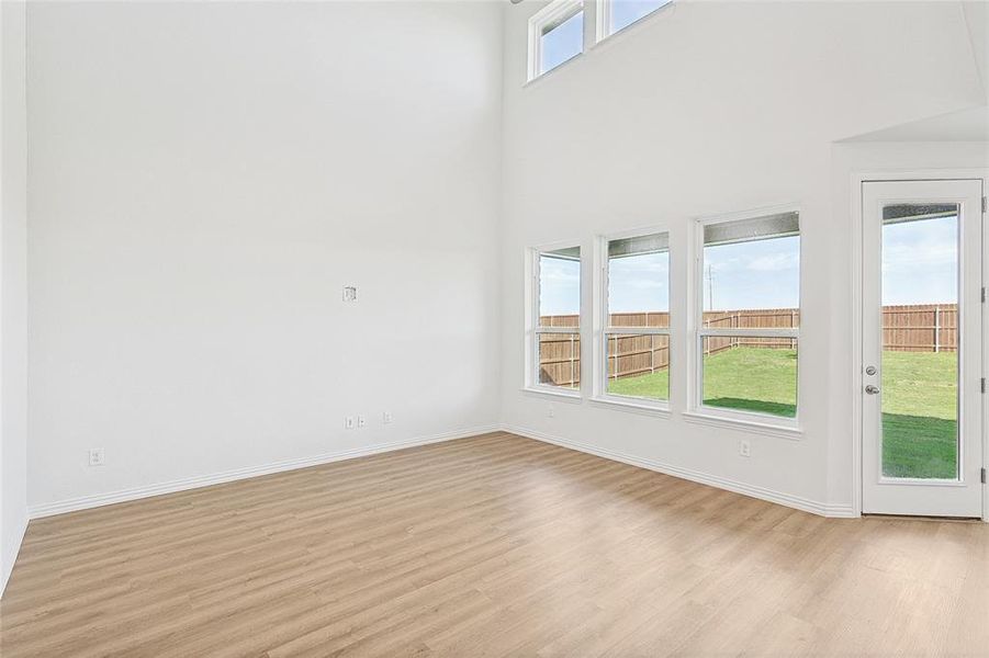 Empty room featuring light hardwood / wood-style floors and a towering ceiling