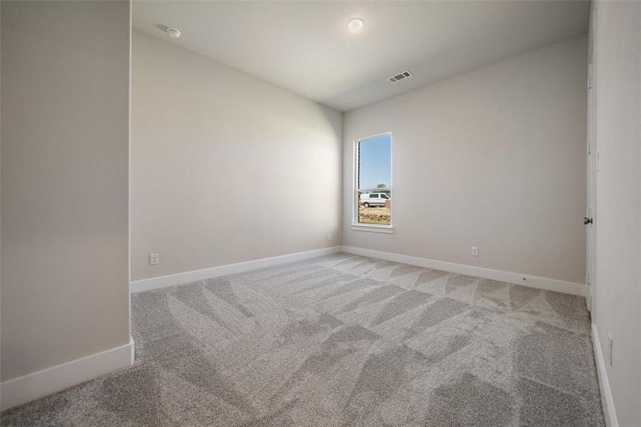 Unfurnished room with light carpet and baseboards Unfurnished room with light carpet and baseboards