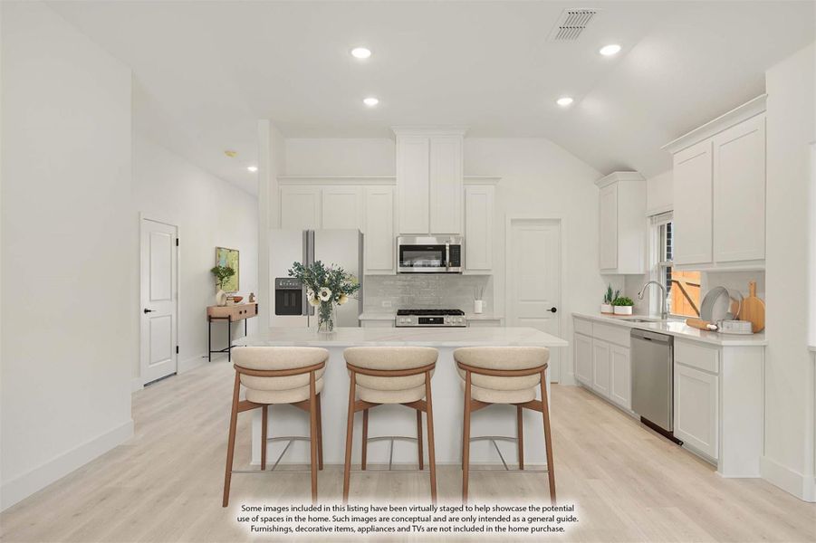 Kitchen with white cabinets, center island with three bar stools, stainless steel appliances, and light wood floors Kitchen with white cabinets, center island with three bar stools, stainless steel appliances, and light wood floors