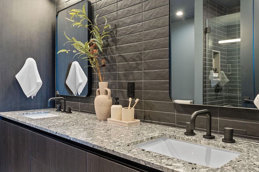Representative Photo. Primary Bath with spacious double vanity, floor to ceiling tile, and a walk in shower