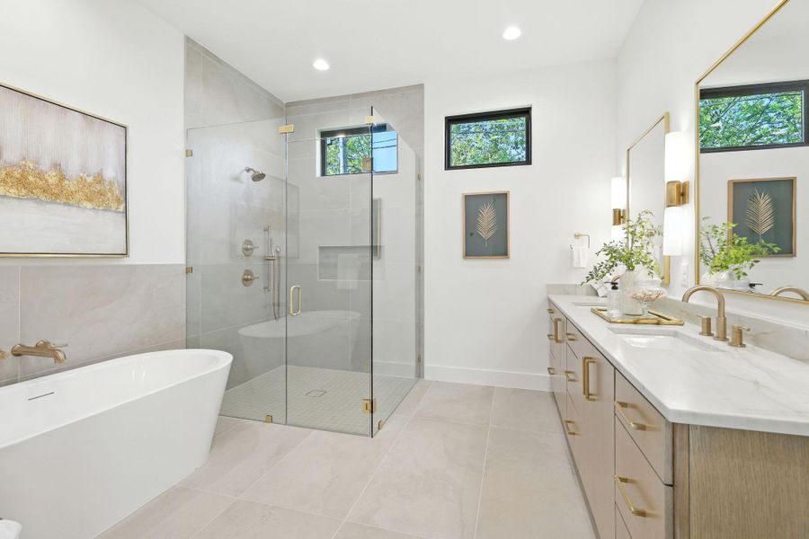 Bathroom featuring double vanity, a soaking tub, a stall shower, light tile patterned floors, and recessed lighting Bathroom featuring double vanity, a soaking tub, a stall shower, light tile patterned floors, and recessed lighting