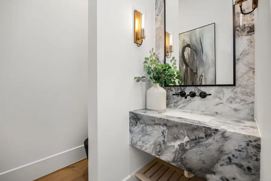 Stunning Powder room offers Dolomite natural stone vanity slab & tall backsplash. High-end and sleek modern black commode. Towel rack under vanity. Stunning Powder room offers Dolomite natural stone vanity slab & tall backsplash. High-end and sleek modern black commode. Towel rack under vanity.