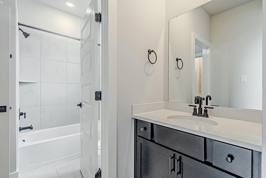 Bathroom with vanity and shower/tub combination.