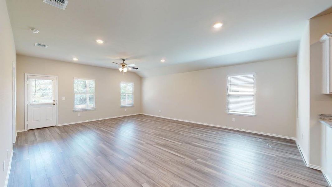 A spacious living area with resilient wood-look flooring and a soaring vaulted ceiling.