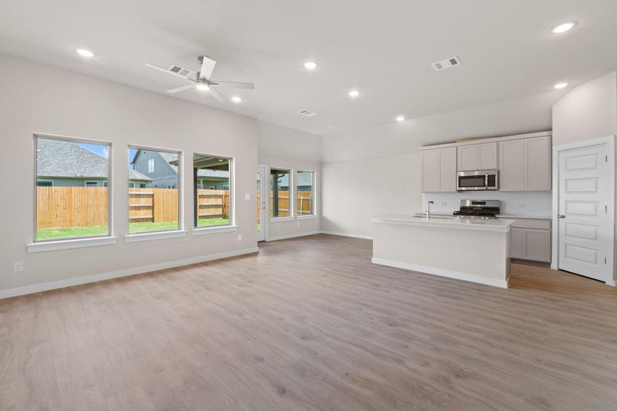 Natural light floods this inviting living space, featuring an open-concept kitchen and durable flooring.