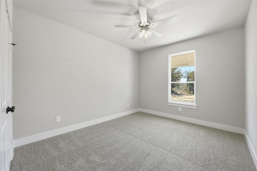 Carpeted spare room featuring baseboards and ceiling fan Carpeted spare room featuring baseboards and ceiling fan