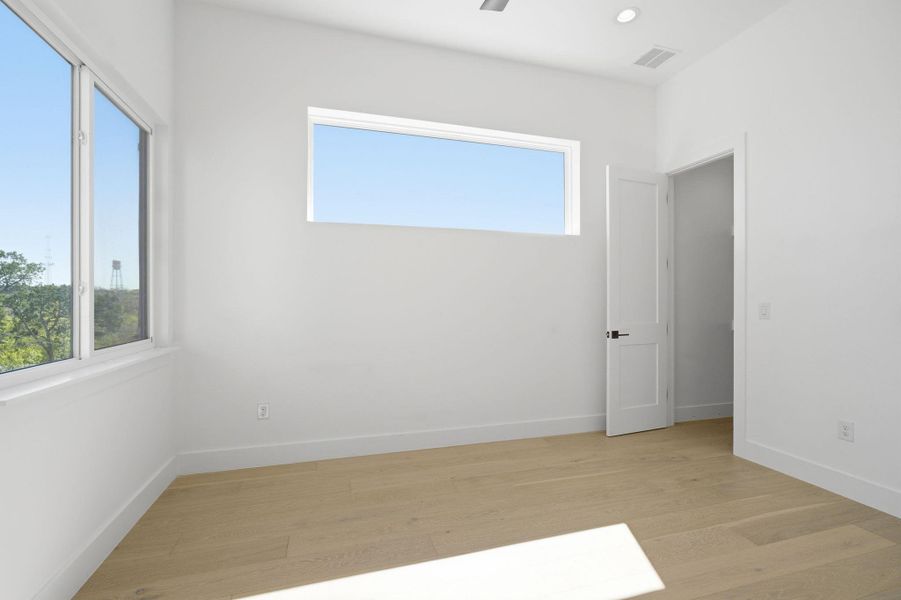 Empty room featuring light wood finished floors and recessed lighting