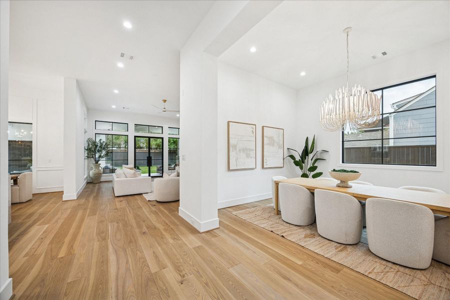 The open-concept design blends dining and living in one cohesive space, enriched by wide-plank oak flooring, tall ceilings, and Pella Reserve windows that maximize light and airflow. The first floor boasts 12 ft ceilings that enhance the spaciousness.