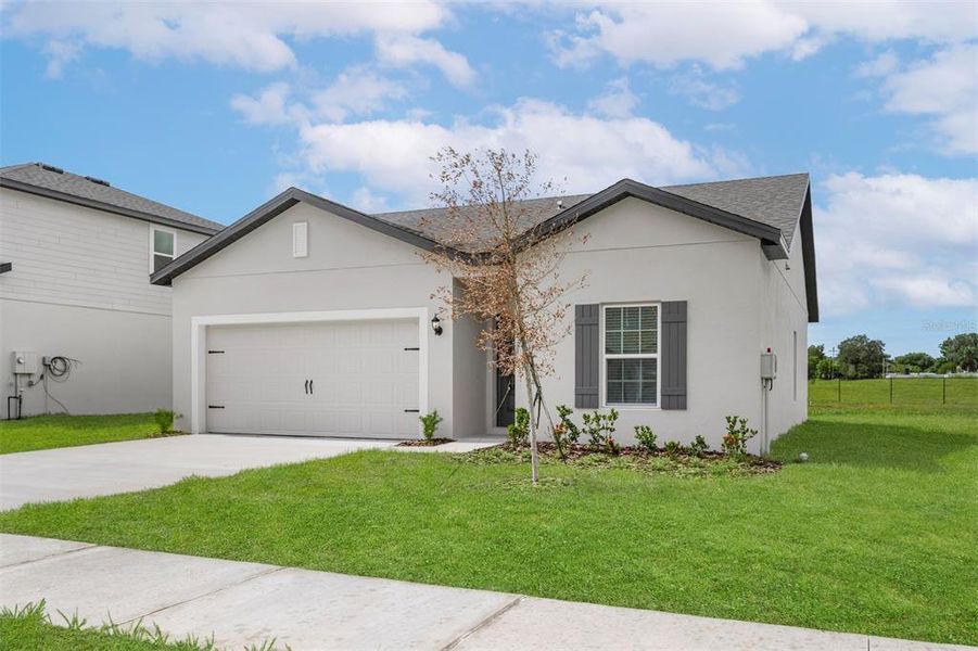 Front exterior of a new home in Tula Parc, Astatula, FL, highlighting curb appeal (Image 2). Front exterior of a new home in Tula Parc, Astatula, FL, highlighting curb appeal (Image 2).