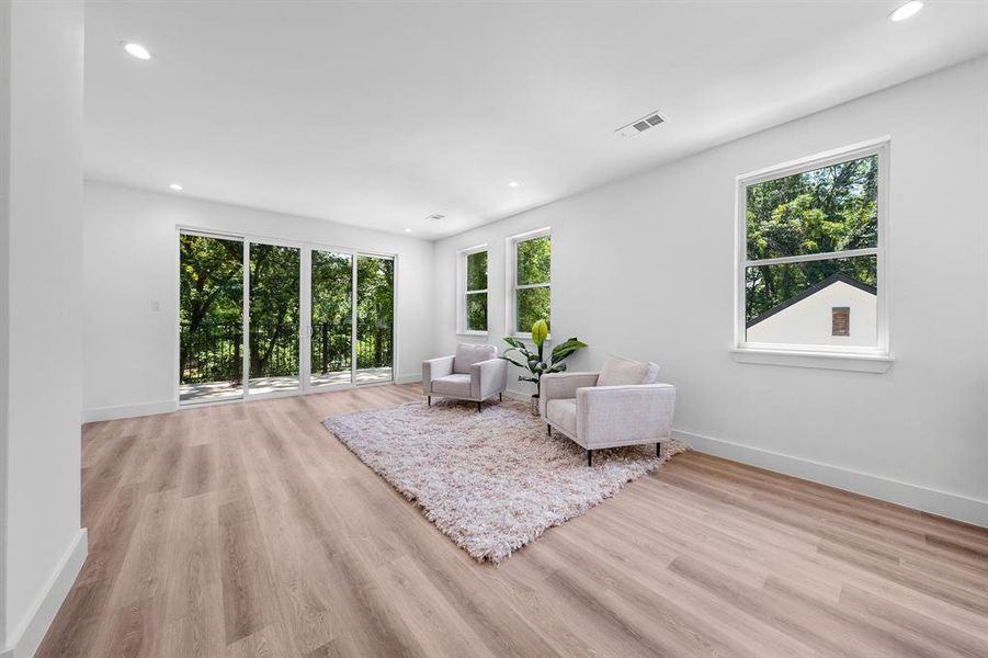 Upstairs living room with recessed lighting, plenty of natural light, and light wood-type flooring Upstairs living room with recessed lighting, plenty of natural light, and light wood-type flooring