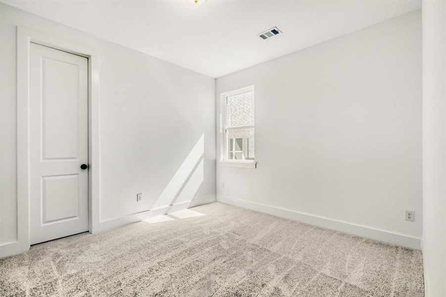 Spare room featuring light carpet and baseboards