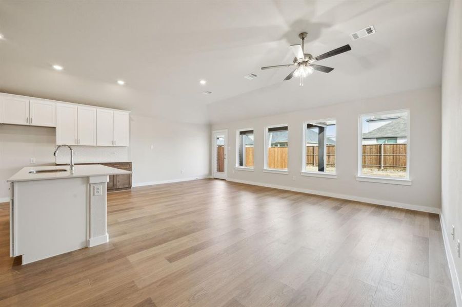 Kitchen featuring light wood-style flooring, open floor plan, and a sink