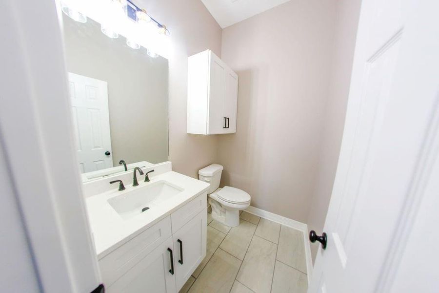 Half bathroom with vanity and light tile patterned floors Half bathroom with vanity and light tile patterned floors