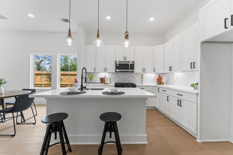 At the heart of this open-concept kitchen lies a stunning oversized island, offering generous prep space, sleek quartz countertops, and seating area. Whether you're hosting a dinner party or enjoying a casual breakfast, this island is the perfect gathering spot. Pendant lighting adds a touch of elegance, while built-in storage and a deep sink make it as functional as it is beautiful.